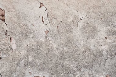 Eski geleneksel kireçlenmiş taş duvar, kabuğu soyulmuş alçı, beyaz kırsal arka plan.