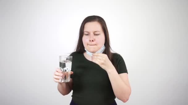 La fille enlève son masque médical et boit un pill.Vaccin contre le coronavirus Séquence Vidéo