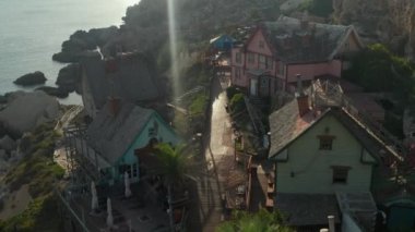 Idyllic Akdeniz Küçük Balıkçı Köyü Kayalıklarda Su Altında Palmiye Ağaçları ile Güzel Öğleden Sonra Günışığı, Hava Dronu Dolly ileri