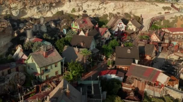 Hermosa vista panorámica del pueblo pesquero mediterráneo en la isla de Malta Gozo, Pequeñas casas de madera en la puesta del sol, Aerial Backwards Dolly — Vídeos de Stock