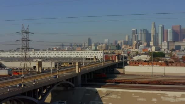 AERIAL: Río LA, vías de tren con el centro de Los Ángeles en el fondo, la luz del sol — Vídeos de Stock