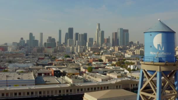 AERIAL: Hacia el centro de Los Ángeles, California Skyline en la hermosa luz del sol, cielo azul, — Vídeos de Stock