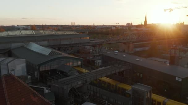 Scenic Aerial Shot van de gele metro Trein invoeren van station verheven boven de grond in Berlijn, Duitsland bij zonsondergang — Stockvideo