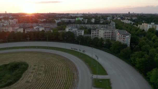 Harness Racers on Dirt Horse Race Track in Berlin, Germany at Sunset, Aerial follow tracking Shot from above — Stock Video