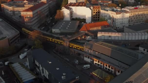 Vista aérea panorâmica do trem amarelo entrando na estação de metrô elevada acima do solo em Berlim, Alemanha — Vídeo de Stock