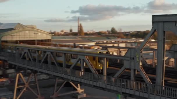 Yellow Subway Train ponte de passagem através do ambiente urbano em Berlim, Alemanha em bela hora de ouro Luz do pôr do sol, rastreamento aéreo siga tiro — Vídeo de Stock