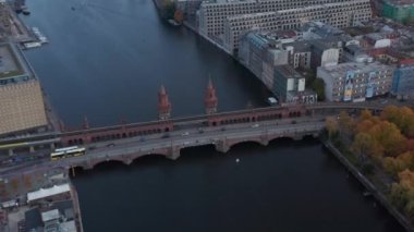 Berlin, Almanya 'da Oberbaum Ünlü Köprüsü' nde yavaş hava akımı. Sarı otobüs ve araba trafiği, İHA Birds Eye View.