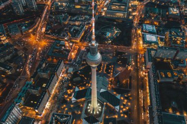 Berlin, Almanya Alexanderplatz TV Kulesi, alacakaranlıkta gün batımından sonra Büyük Şehir Şehri manzarasının turuncu ışıklarıyla aydınlatılmış güzel caddelerle, hava manzarasıyla