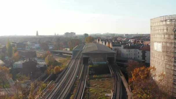 ドイツの大都市ベルリンの通りの上にある空の駅美しい秋の夕日、空中ドリーで — ストック動画