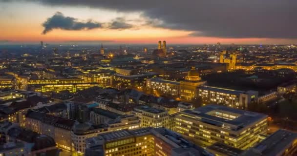 Atemberaubendes Münchner Stadtbild bei Nacht mit leuchtenden Straßen und Bürogebäuden, magischer Tag-Nacht-Hyperlapse, der im Zeitraffer über dem Großraum München kreist