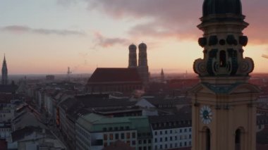 Frauenkirche Katedrali klasik Münih 'in eski bir kasabasında, Noel Alışveriş Sokağı' nda kışın Cityscape 'e bakarken, Hava Dronu geriye doğru, Dolly Sarı Kilise Kulesi' ni ortaya çıkarırken,