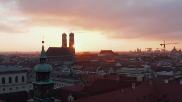 Słynna niemiecka katedra Frauenkirche o zachodzie słońca Złote Godziny światła, znajduje się w centrum Monachium w Bawarii, zjeżdżalnia Aerial Dolly lewo ze słońcem odsłaniając za wieżą kościelną — Wideo stockowe