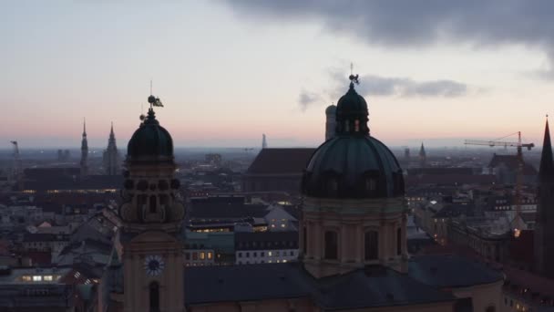 Dolly avanza a través de dos torres de la iglesia Catedral de Theatinerkirche en Munich, Alemania, aérea en la noche después de la puesta del sol, anochecer — Vídeo de stock