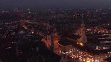 Almanya 'da gece vakti Münih' in çatıları üzerinde uçuş, Marienplatz ve Manzaralı Şehir ışıkları parlayan Güzel Katedraller,