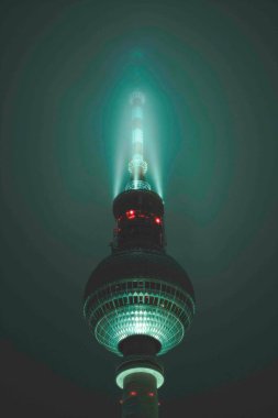 Manzaralı Manzara Berlin 'in ünlü Alexanderplatz TV Kulesi, Almanya' nın Renkli Turkuaz Rengi Gece Sisi ile çevrili, Anteni Kapat