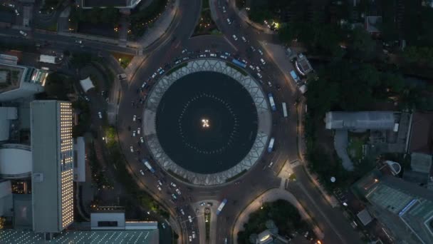 Aviões Aéreos Eye Overhead Visão estática de cima para baixo de veículos dirigindo em torno de uma movimentada rotunda do Monumento Selamat Datang à noite — Vídeo de Stock