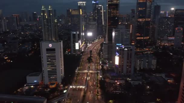 Luchtopname van het verkeer op de meerbaans snelweg door het moderne stadscentrum in de nacht in Jakarta, Indonesië — Stockvideo