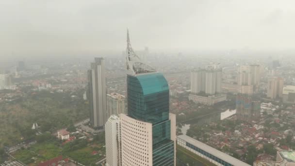 Close up aerea dolly shot della cima del grattacielo Wisma 46 a Jakarta, Indonesia in una giornata nuvolosa — Video Stock
