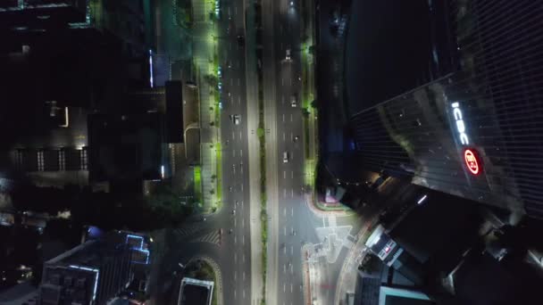 Воздушные птицы Глаз сверху Вниз Вид на движение города ночью рядом со зданием небоскреба и огнями города мигающие в Джакарте, Индонезия — стоковое видео