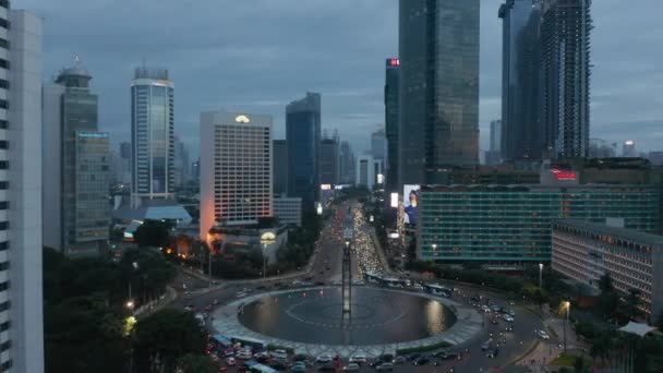 Foto de muñeca aérea de tráfico de hora pico ocupado en una gran rotonda rodeada de rascacielos en Yakarta, Indonesia — Vídeo de stock