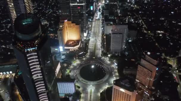 Letecký noční dron pohled se blíží k Selamat Datang Monument kruhový objezd s rychlou automobilovou dopravou v Jakartě, Indonésie — Stock video