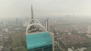 Cakarta, Endonezya 'da bulutlu bir günde Wisma 46 gökdeleni anteninin etrafını çevreleyen hava manzarasını kapatın.