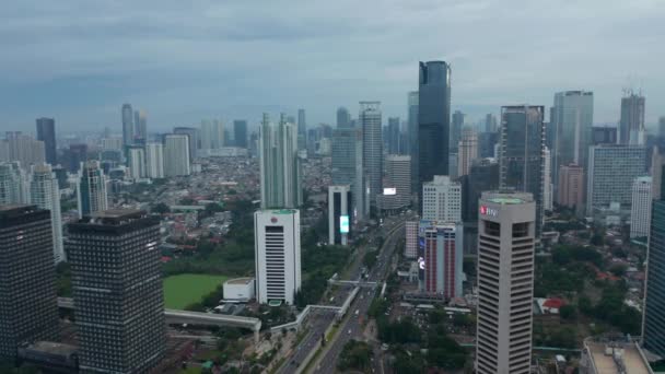 Vista aérea amplia del Cañón Urbano con rascacielos y tráfico de varios carriles en el centro de Yakarta, Indonesia, vista moderna de la ciudad asiática Drone — Vídeo de stock