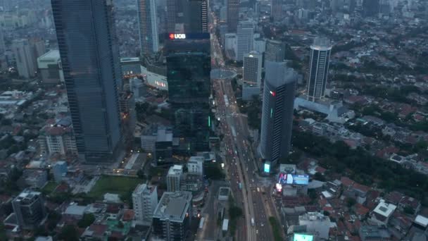 印度尼西亚雅加达现代城市中心，在繁忙的多车道道路上和黄昏时分的回旋处用飞机拍下的车辆 — 图库视频影像