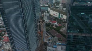 Gökdelenler arasından uçarak Jakarta, Endonezya 'daki küçük yeşil yerleşim bölgesine doğru uçan kule görüntüsü