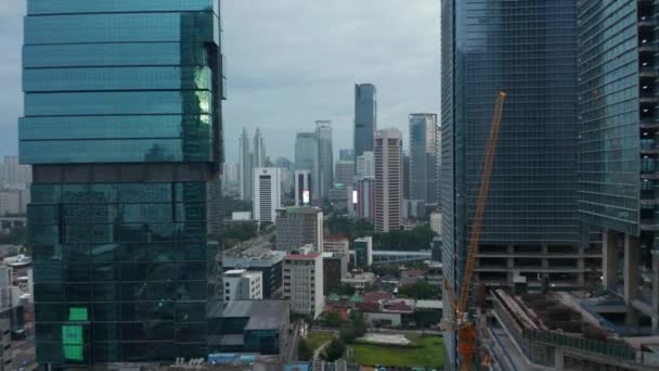 ジャカルタの2つのガラス高層ビルの間のダウンタウンの高層ビルへの空中前方飛行、インドネシア — ストック動画