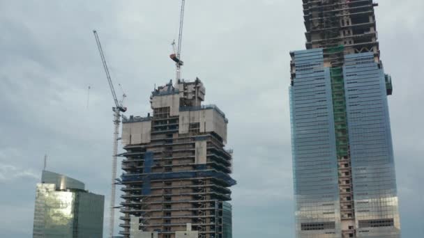 Flygande piedestalskott av en skyskrapa tornbyggnad under uppförande i Jakarta, Indonesien på en molnig dag — Stockvideo