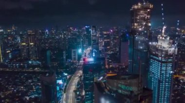 Modern şehir merkezinin yukarısında, modern Jakarta, Endonezya, Hava Dronu 'nun hiperaktifleştirilmiş çekimlerinde gökdelenler ve yoğun araba trafiğiyle Hiper Hız Hızı Hareketi Gecesi