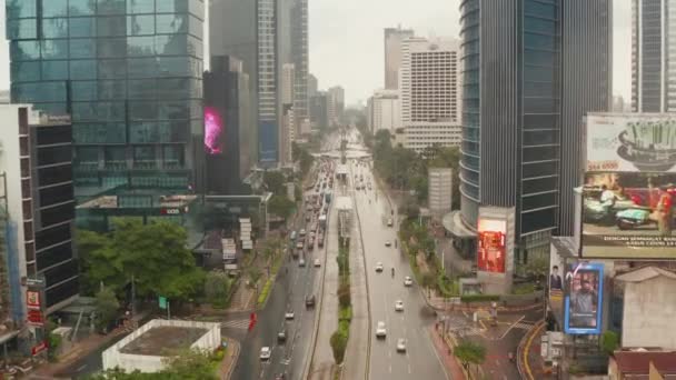 Pedestal aéreo basculante de vehículos en una autopista de varios carriles en el centro de la ciudad moderna de Yakarta — Vídeo de stock