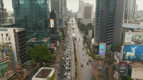 Piedistallo discendente inclinazione aerea colpo di traffico multi corsia e tram trasporto pubblico si avvicina nel centro urbano della città di Giacarta — Video Stock