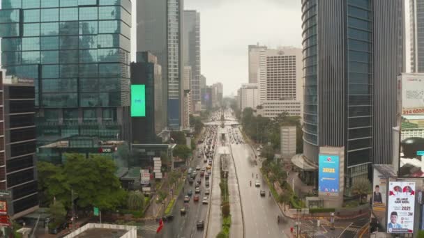 Retiro aéreo dolly baja volando disparo de vehículos en una carretera de varios carriles en el centro de la ciudad de Yakarta en un día nublado — Vídeo de stock