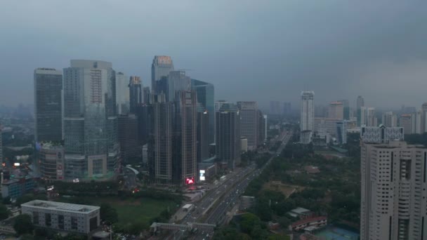 Brede antenne dolly shot van meerdere hoge glazen wolkenkrabbers en brede multi lane snelweg in het moderne centrum van Jakarta — Stockvideo