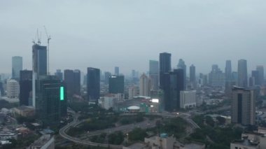 Hava aracı Jakarta 'daki şehir merkezindeki gökdelenlere doğru çok şeritli otoyol kavşağında uçarken çekildi.