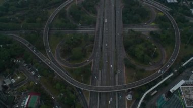 Modern şehir merkezindeki araçlarla dolu çoklu şeritli kavşakta uçan havadan kumandalı çekimler.