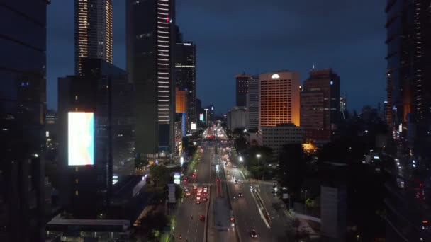 Baixo voo aérea dolly tiro de carros em uma estrada multi pista movimentada no centro da cidade de Jacarta à noite — Vídeo de Stock