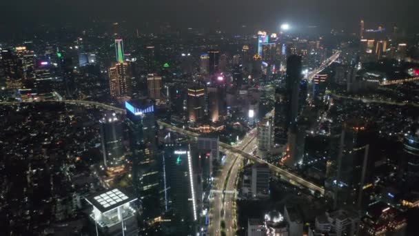 Amplia fotografía aérea al revés de una gran intersección de carreteras en el moderno centro de la ciudad de Yakarta con rascacielos altos — Vídeo de stock