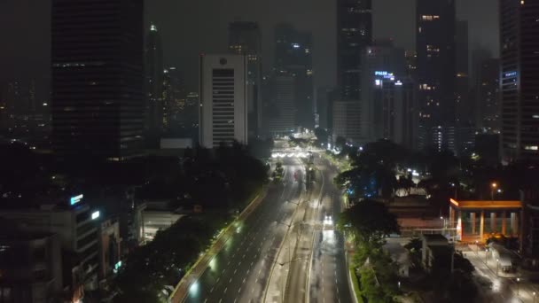Letecká Dolly vpřed létání záběr téměř prázdné víceproudové dálnice v noci během covid 19 coronavirus uzamčení pandemie ve velkém centru města v Jakarta — Stock video