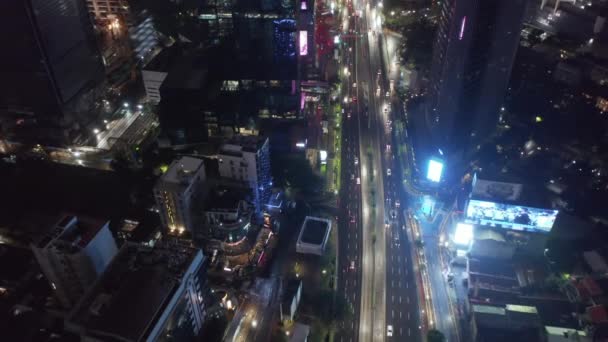 Tilting tiro aéreo volando hacia los coches en una carretera por la noche en el centro urbano de la ciudad metropolitana de Yakarta — Vídeo de stock