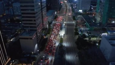 Jakarta 'da kırmızı ışıkta trafiği durduran çok şeritli bir otoyolda havadan çekilen görüntüler.
