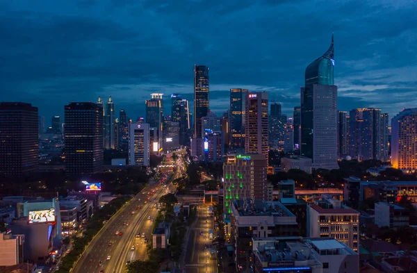 Jakarta, Endonezya 'daki büyük şehir merkezindeki gökdelenler ve çok şeritli otoyol gece görüş alanına giriyor.
