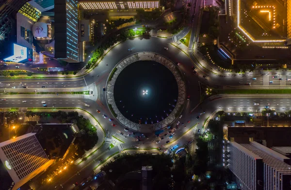 Πάνω προς τα κάτω εναέρια άποψη της κίνησης της κυκλοφορίας αυτοκινήτων σε κυκλική κυκλοφορία οχημάτων γύρω από Selamat Datang μνημείο στην Τζακάρτα, Ινδονησία τη νύχτα — Φωτογραφία Αρχείου