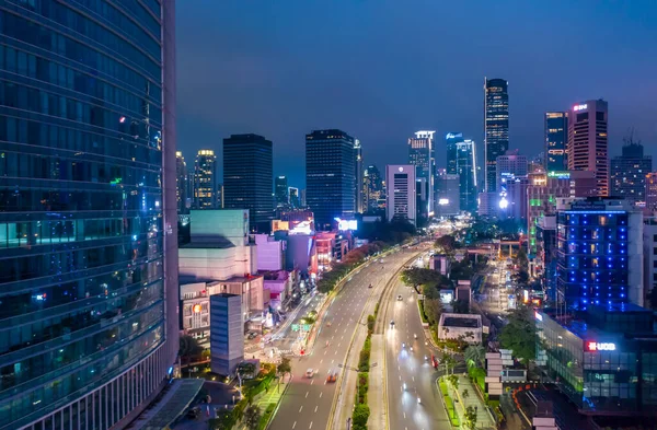 Endonezya 'nın merkezindeki Jakarta şehrinden geçen gökdelenlerle birlikte şehir merkezinden geçen çok şeritli otoyol üzerindeki hava gece görüşü.