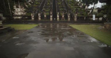 Pura Penataran Agung Tapınağı merdivenlerindeki su birikintilerinin ve Endonezya 'nın Bali kentindeki muhteşem kaya binalarının ve ünlü turistik ilgi odağı heykellerinin çekimleri.