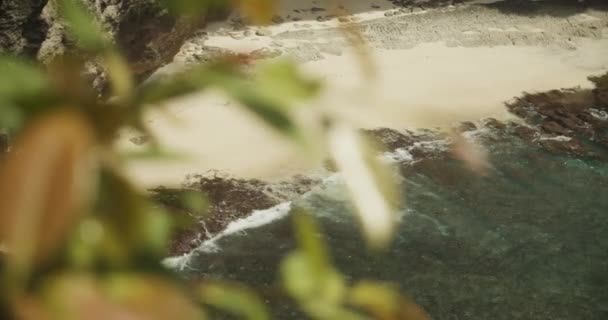 Close up rivelano le onde che lentamente si schiantano sulla splendida spiaggia di sabbia tropicale circondata da scogliere a Broken Beach Pasih Uug a Bali Indonesia — Video Stock
