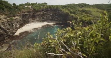 Endonezya 'daki Broken Beach Pasih Uug' da mavi denizi ve sarp okyanus kayalıkları olan göz kamaştırıcı, tenha tropikal kumlu bir plajı gözler önüne seriyor.