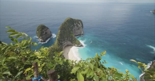 Duwen in onthullen schot van prachtige tropische strand met blauwe zee en rotsachtige schiereiland Kelingking strand en T-Rex Bay in Bali, Indonesië met turquoise blauw water en zandstrand van boven — Stockvideo